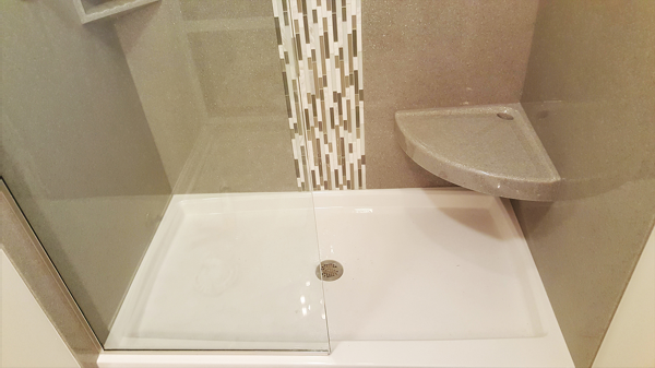 Low-threshold shower pan with corner seat