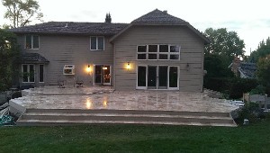 Wide patio and steps across the back of a home at dusk