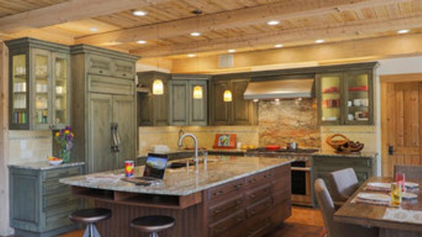 Kitchen with green glazed cabinetry and knotty pine ceiling